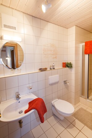 A bathroom with a sink, toilet, and mirror. - Ferienwohnungen Widdmoos (Ruhpolding)