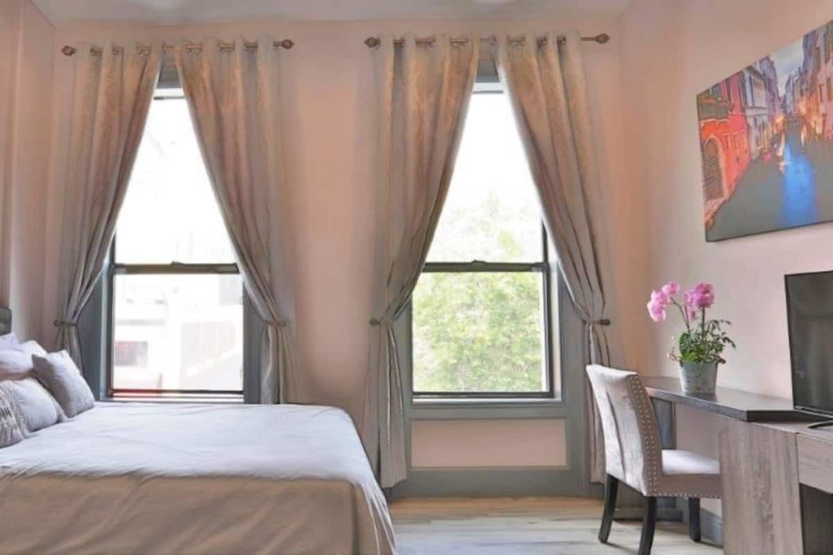 Escritorio, cortinas blackout y tabla de planchar con plancha