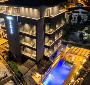 A multi-story hotel with outdoor seating and a swimming pool. - Hotel Piramida (Ksamil)