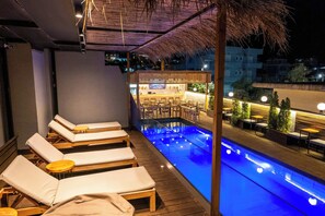 A rooftop bar with lounge chairs and a pool. - Hotel Piramida (Ksamil)