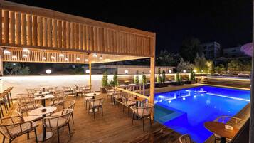 Una piscina al aire libre de temporada, sombrillas