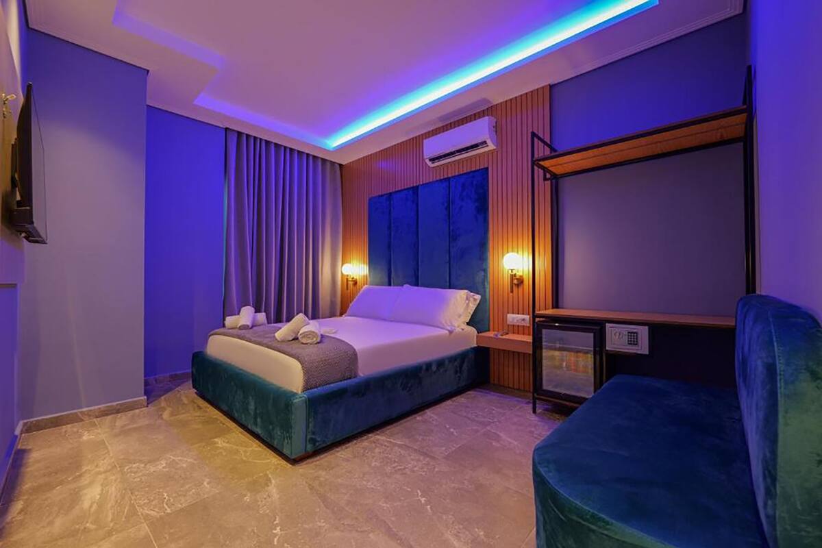 Una habitación de hotel moderna con una cama grande, un escritorio y una silla.