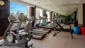 Un gimnasio con cintas de correr, pelotas de ejercicio y máquinas de pesas.