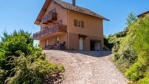 A two-story house with a balcony, a garage, and a gravel driveway. - Homerez - Apartment in Cornimont (Cornimont)
