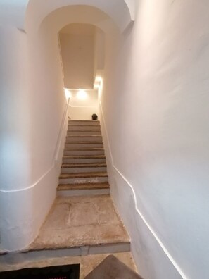 Un escalier étroit avec des marches en pierre menant à un palier.