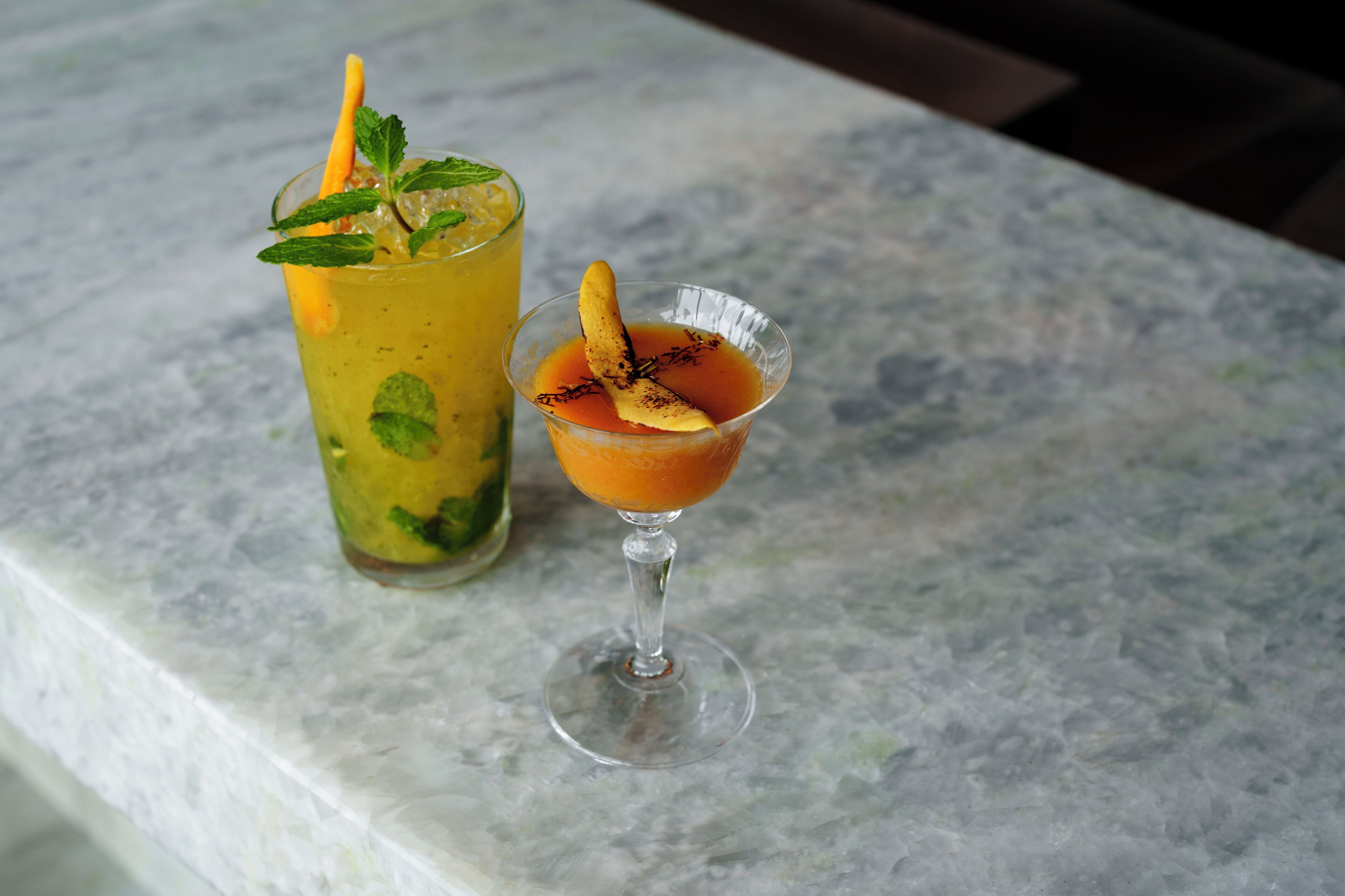Two drinks on a marble surface.