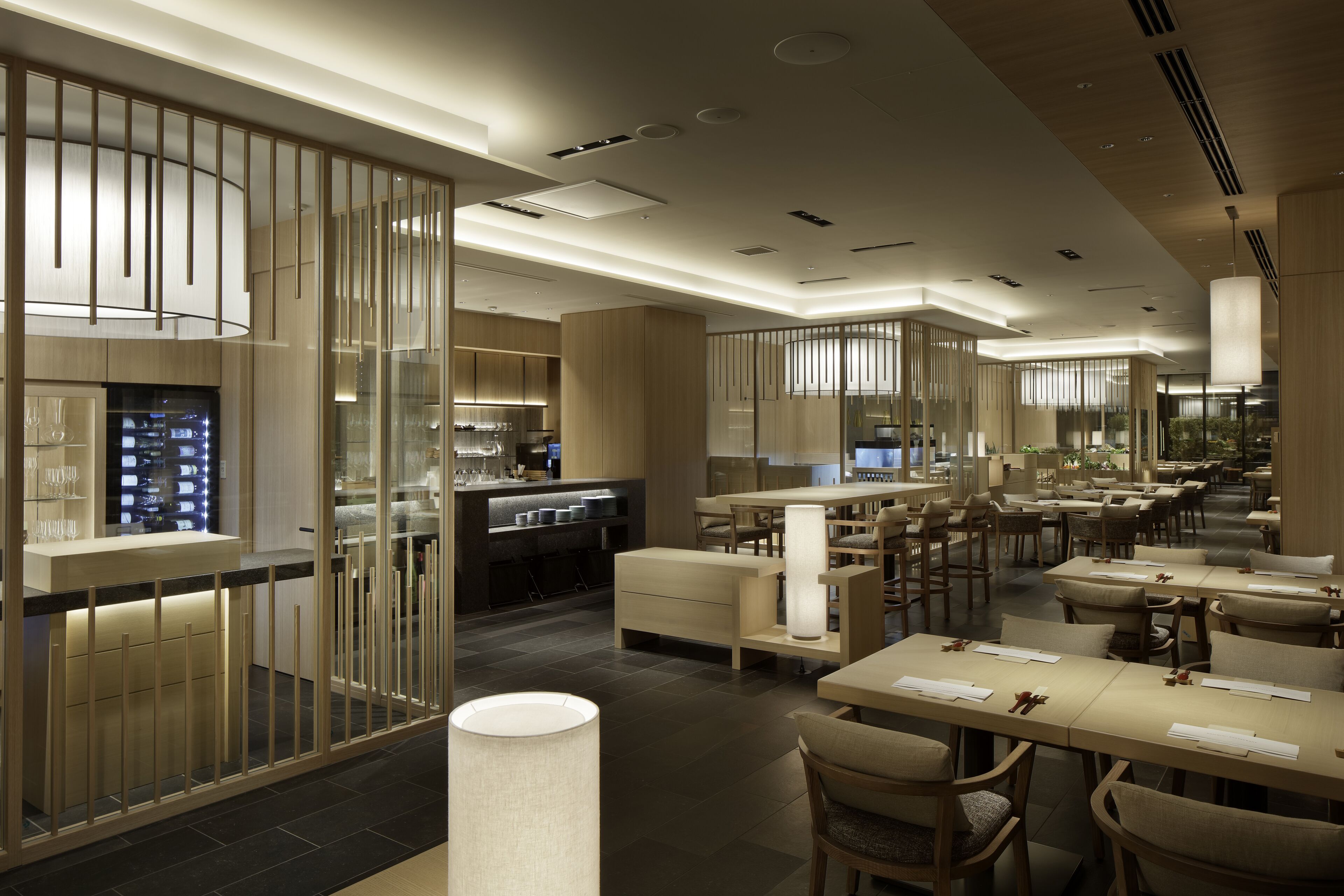 A modern restaurant with a clean, minimalist design, featuring a mix of dining and bar areas, and a contemporary interior with neutral tones and ample lighting.