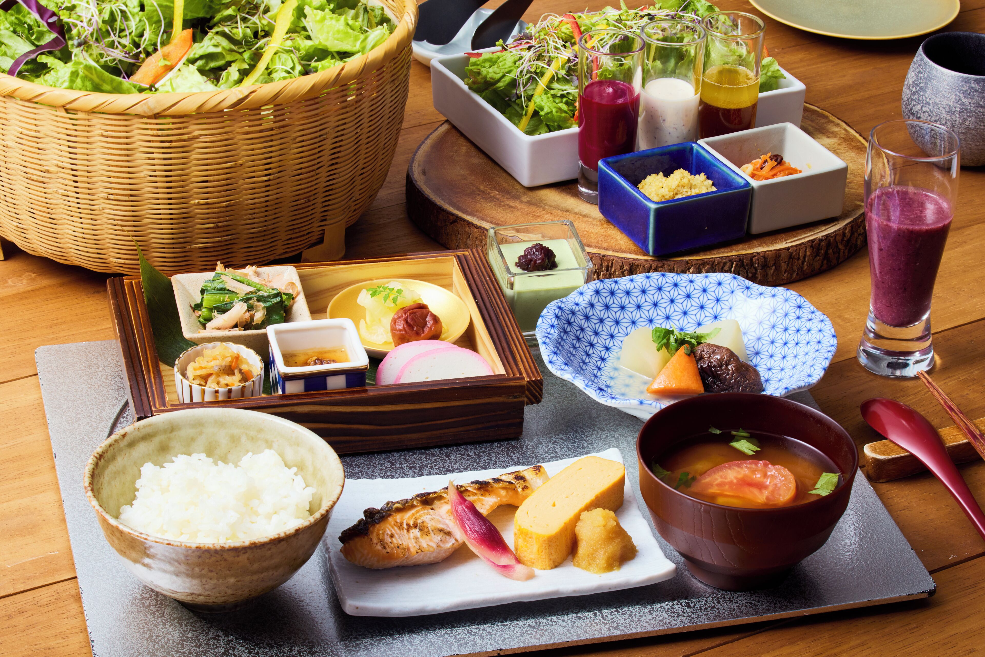 A variety of Japanese dishes including sushi, rice, and soup, arranged on a wooden table.
