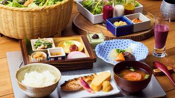 A variety of Japanese dishes including sushi, rice, and soup, arranged on a wooden table.
