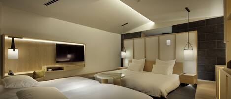 A modern hotel room with two beds, a flat-screen TV mounted on the wall, and a large window with a view of the city.