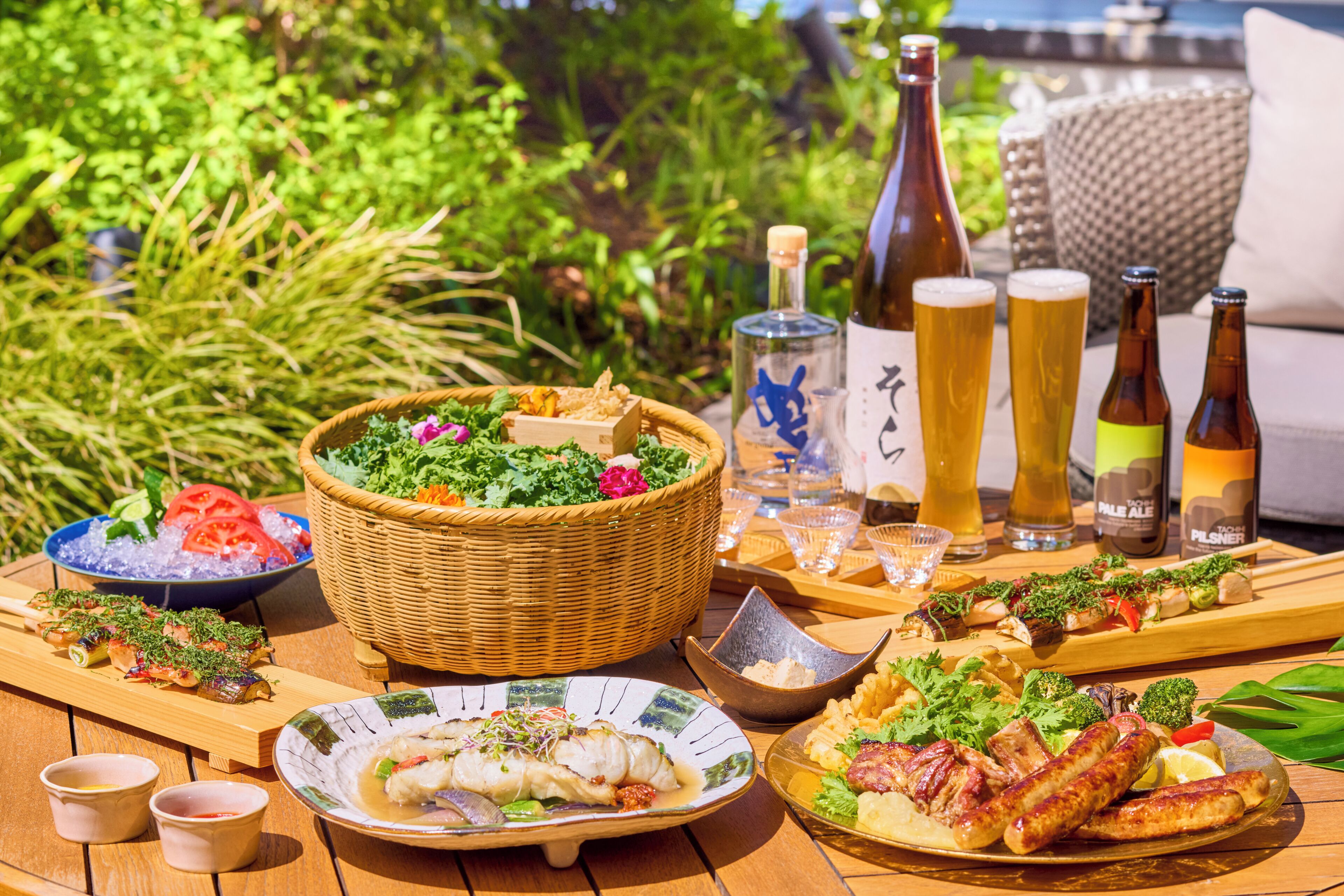 A table set with various dishes, drinks, and a basket of salad.