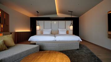 A modern bedroom with a large bed, a sofa, and a round coffee table.