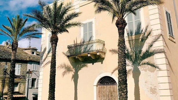 A building with a balcony and a wooden door. - Soothing 4-person apartment in the heart of Erbalunga (Erbalunga)