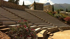 A stone amphitheater with tiered seating, surrounded by stone walls and vegetation. - Soothing 4-person apartment in the heart of Erbalunga (Erbalunga)