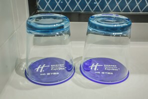 Two transparent containers with blue lids and labels, placed on a white surface.
