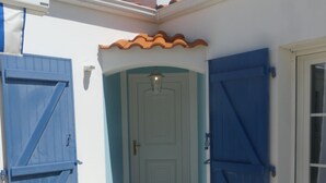 A building entrance with two blue doors, a white door, and a tiled floor. - Chambre d'hôte Blanche Pierre B&B (Le Perrier)