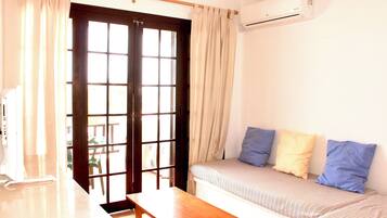 Una habitación con cama, una mesa y aire acondicionado.