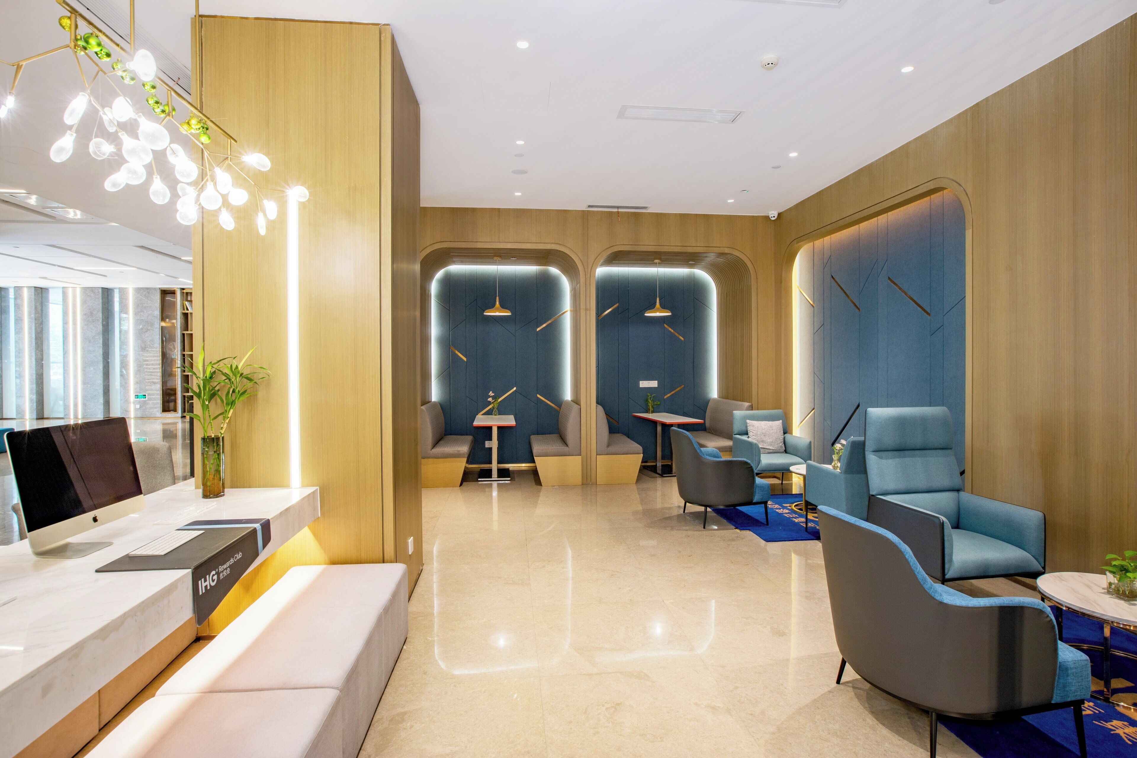 Un moderno vestíbulo de hotel con mostrador de recepción, zonas de estar y un ventanal que proporciona luz natural.