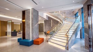 A modern lobby with a curved staircase, seating areas, and a reception desk. - Holiday Inn Express Changzhou Xinbei by IHG (Changzhou)