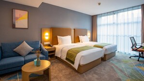 A hotel room with two beds, a sofa, a coffee table, and a desk with a chair. - Holiday Inn Express Changzhou Xinbei by IHG (Changzhou)