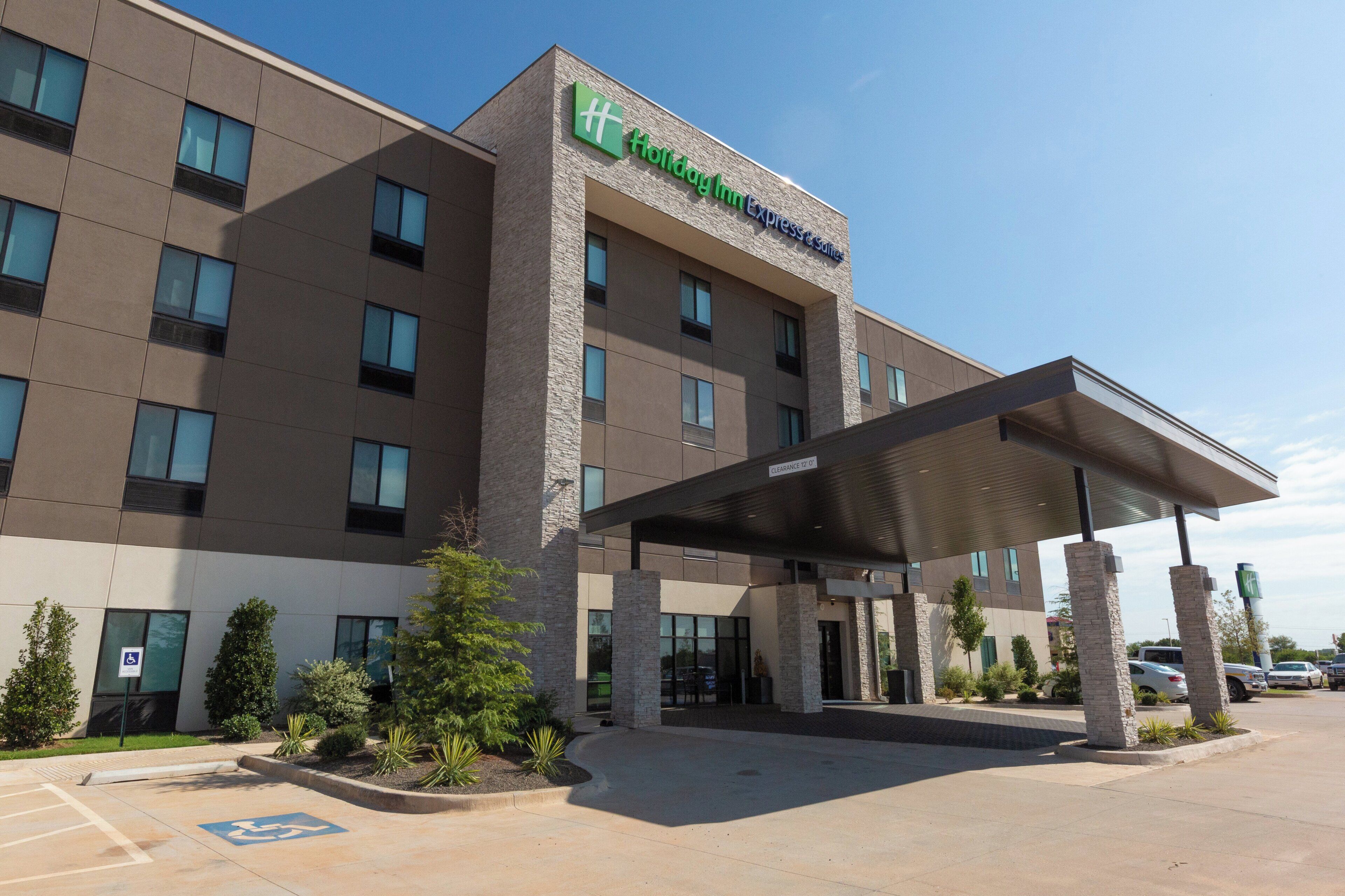 A hotel with a modern design, featuring a covered entrance and a clear sky.