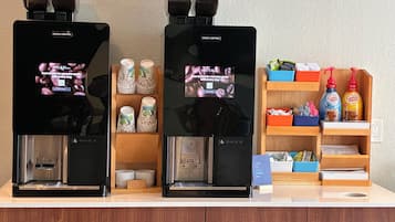 Deux machines à café, une pile de gobelets en papier et une étagère remplie d’articles liés au café.