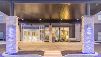 Stunning building entrance with a glass door and seating area.