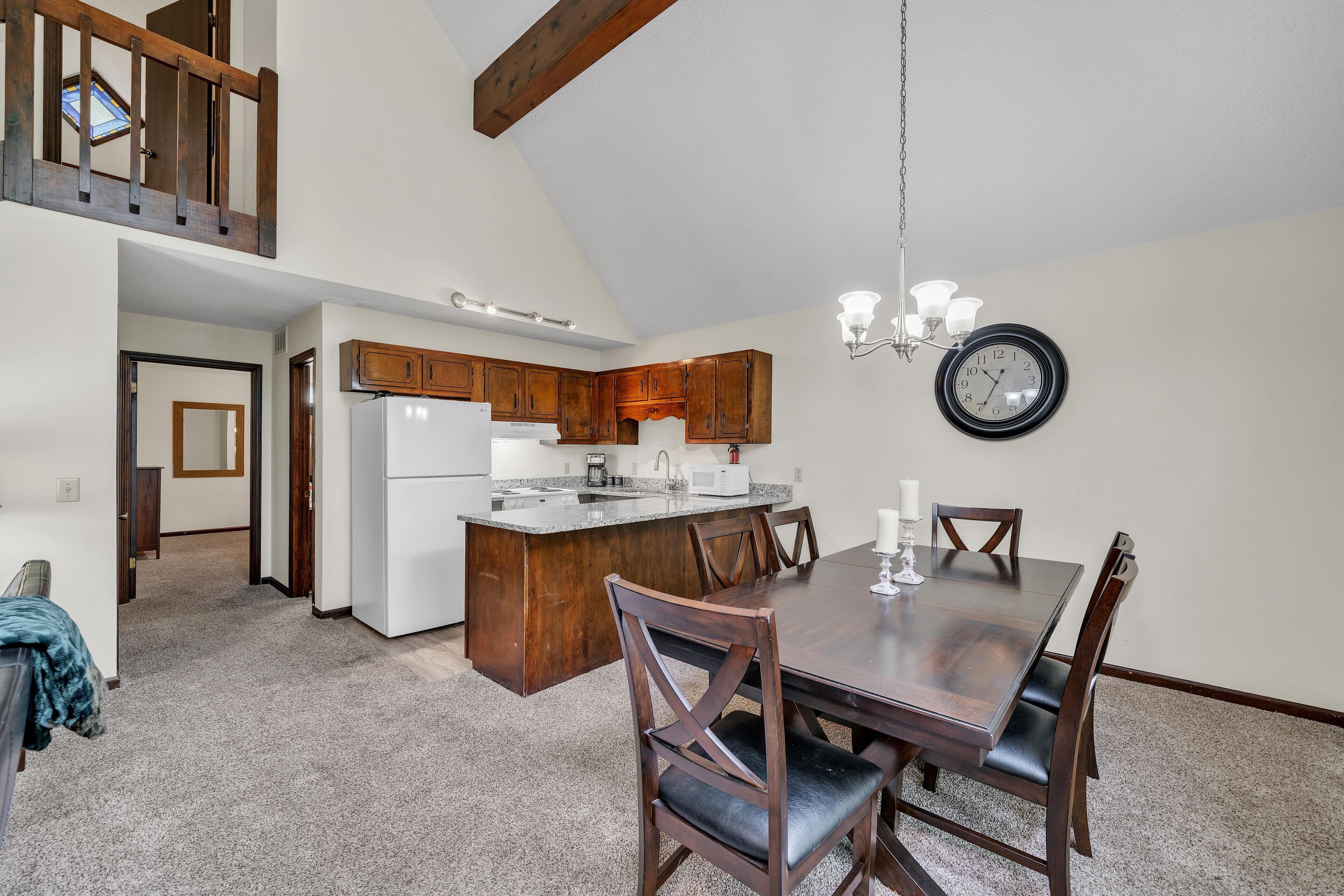 A spacious kitchen with wooden cabinets, a central island, and a dining area with a large table and chairs.