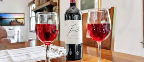 A bottle of wine and two glasses on a wooden table.