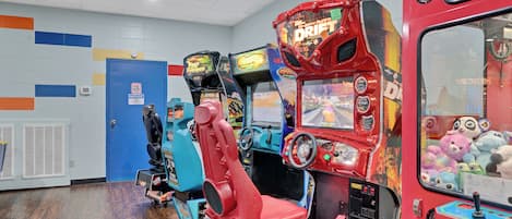 A row of arcade machines with a blue door and a red machine labeled "DRIFT" in the background.