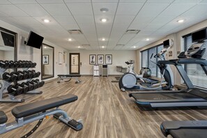 A gym with treadmills, a stationary bike, and weightlifting equipment.