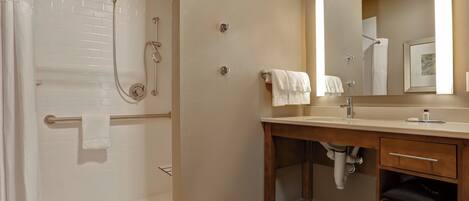 A modern bathroom with a walk-in shower, a vanity with a mirror, and a toilet.
