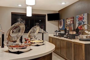 A buffet setup with various food items and condiments.