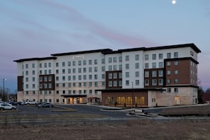 A Staybridge Suites hotel with multiple floors, a parking lot, and a well-lit entrance. - Staybridge Suites Overland Park - Kansas City S by IHG (Overland Park)