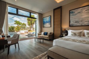 Un dormitorio amplio con una cama grande, un sofá, un escritorio y vistas a una piscina y zona exterior.