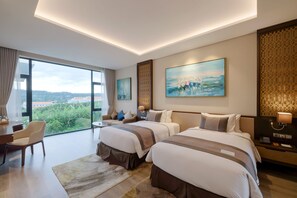 Habitación de hotel moderna con dos camas, un escritorio y un ventanal grande con vistas a la ciudad.