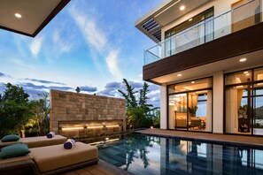 A modern house with a swimming pool, a stone wall, and a balcony overlooking the pool. - Wyndham Grand KN Paradise Cam Ranh (Bac Cam Ranh)
