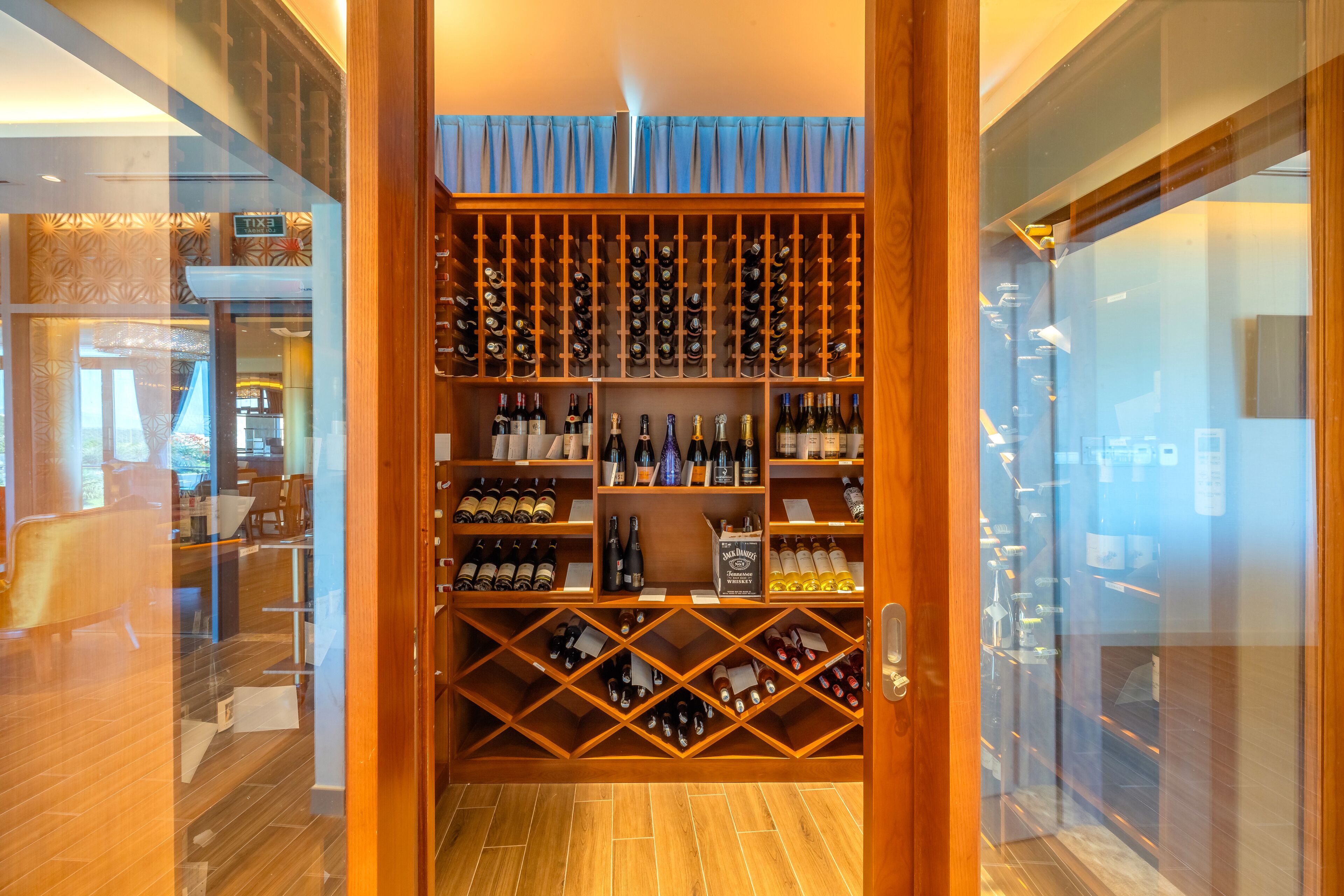 A wine cellar with multiple rows of wine bottles and a small display case.