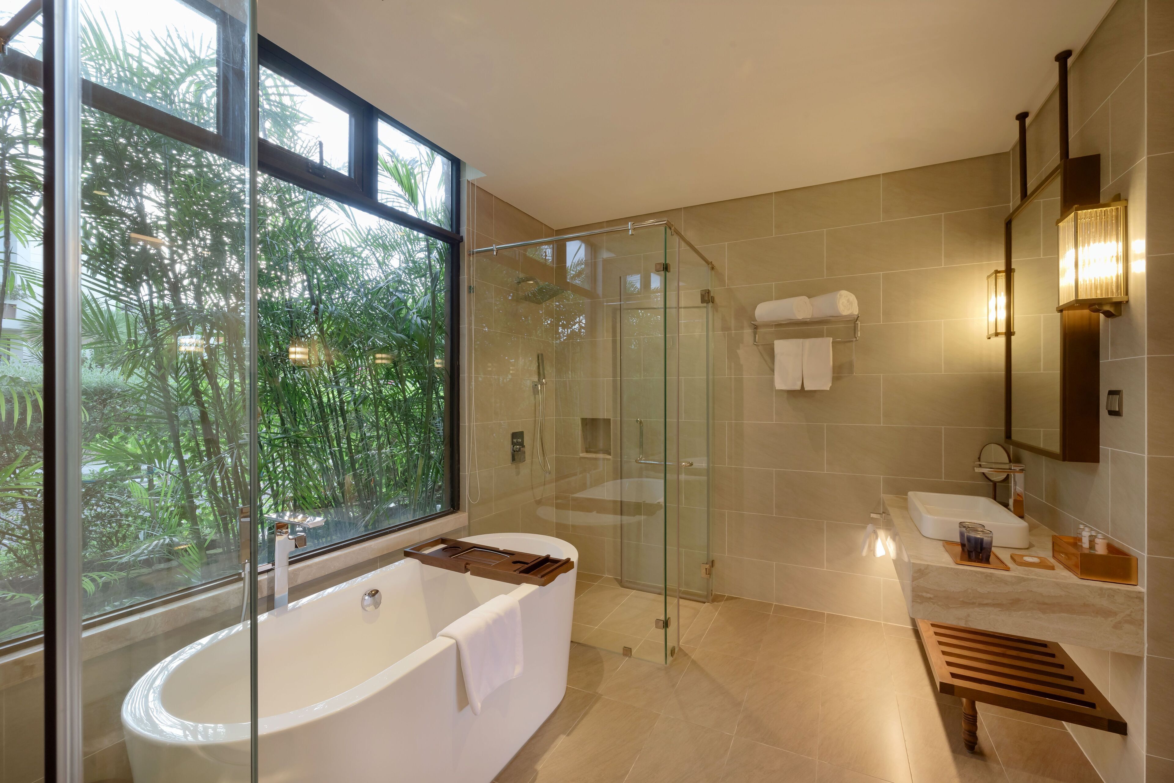 A modern bathroom with a glass-enclosed shower, a freestanding bathtub, and a vanity with a mirror.
