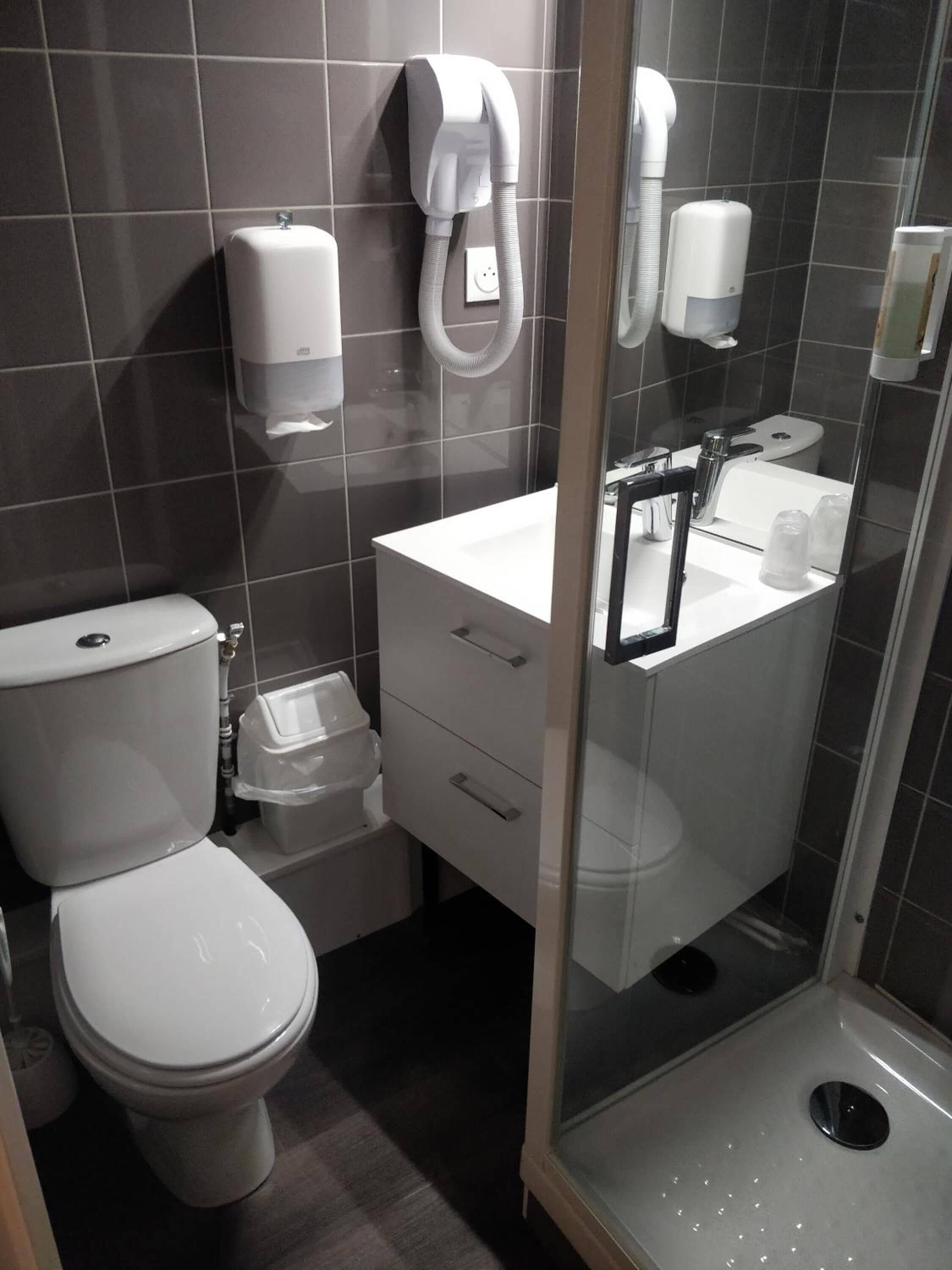 A modern bathroom with a toilet, a sink, and a shower stall.