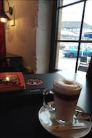Una mesa con una taza de café y un menú.