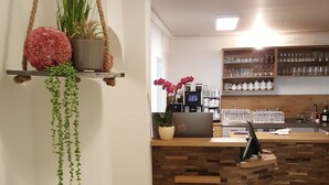 Ett modernt kök med en bänkskiva i trä, en hängande växt och en kaffemaskin.