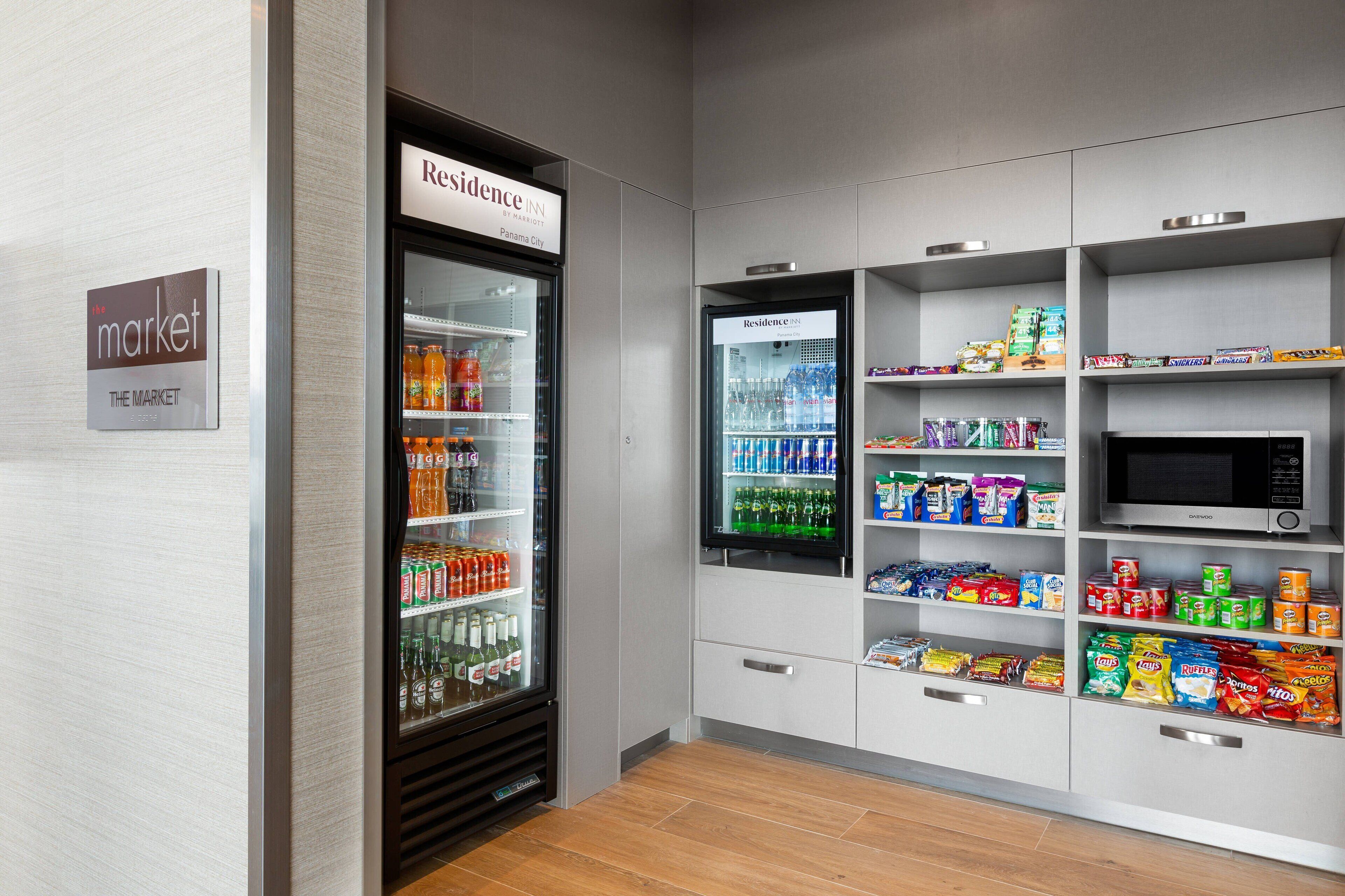 Un área de venta con refrigerador y microondas, provista de bebidas y aperitivos.