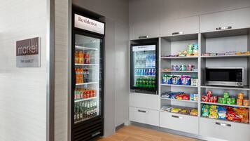 Un área de venta con refrigerador y microondas, provista de bebidas y aperitivos.