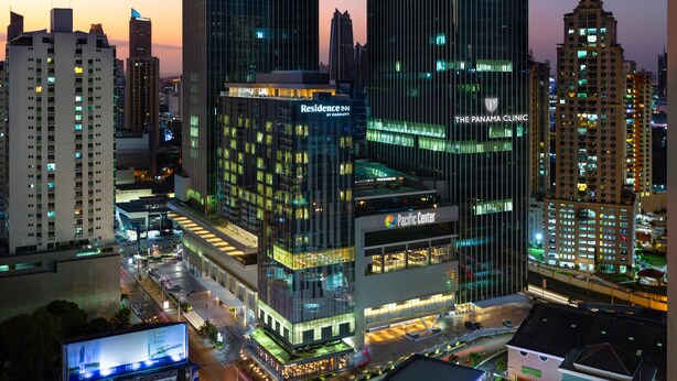 Un hôtel de grande hauteur, avec de nombreux étages, une enseigne bien visible indiquant « Residence Inn by Marriott » et une autre indiquant « Panama Clinic ».