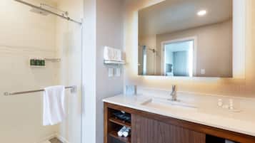 Une salle de bain moderne avec une douche, un meuble-lavabo et un grand miroir.