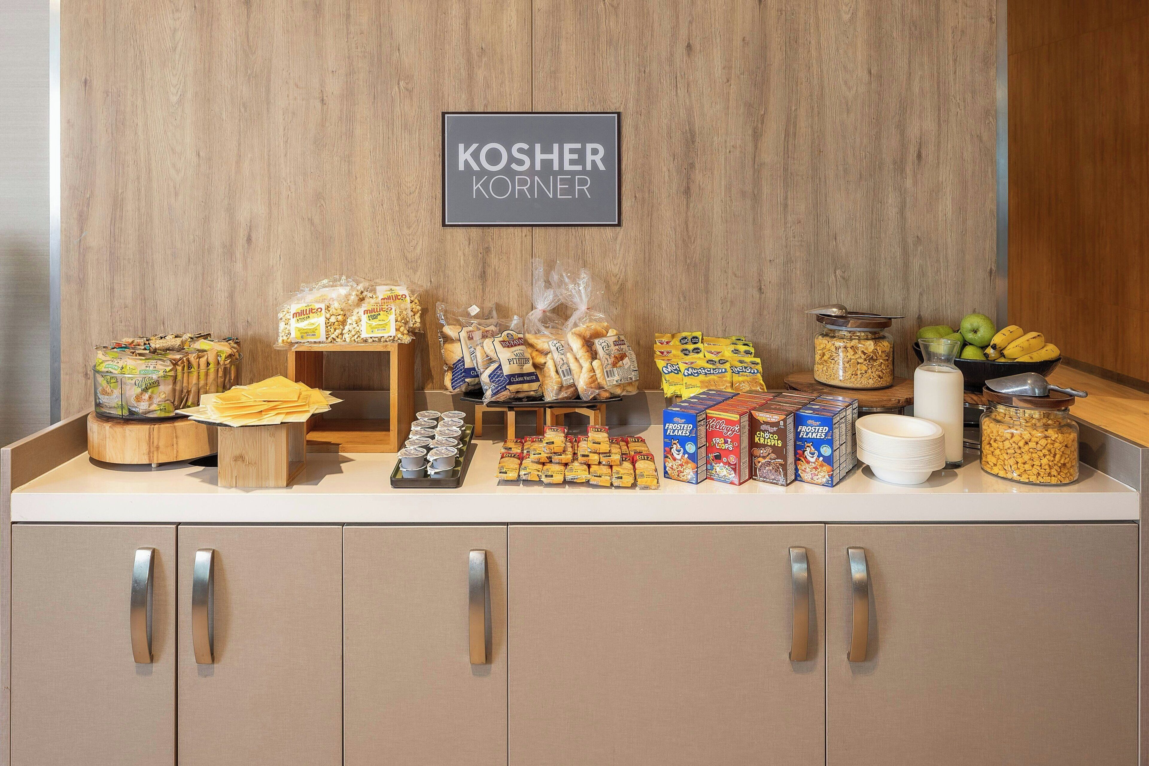 A kosher food display with various snacks and cereals.
