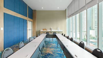 A conference room with a long table, chairs, and a carpeted floor.