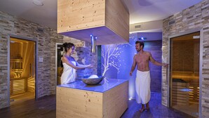A sauna area with wooden benches and a central stone basin. - Hotel La Torretta (Vermiglio)