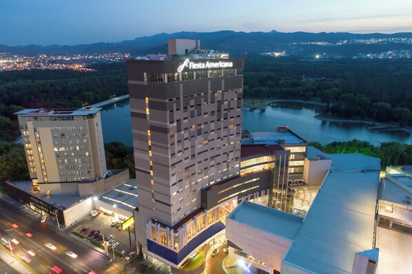 A multi-story hotel with a prominent 'Fiesta Americana' sign, surrounded by a parking lot and a river view. - Fiesta Americana San Luis Potosi (San Luis Potosi)